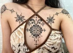 a woman with tattoos on her chest and shoulder