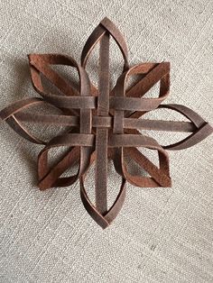 a piece of wood that is shaped like a flower on a tablecloth with a white background