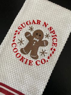 a close up of a towel with a ginger cookie on it and the words sugar n'spice co