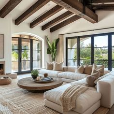 a living room with couches, tables and windows