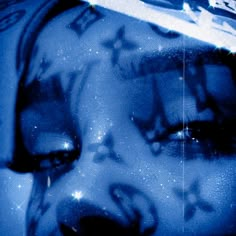 a woman's face is covered in blue paint