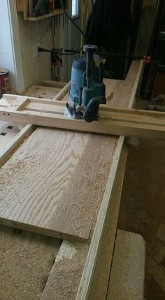 a person using a router to cut plywood planks in a room that is being worked on