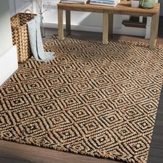 an area rug with a wooden table and vases on the floor next to it