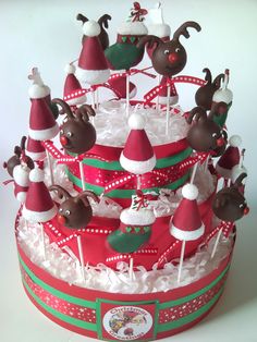 a christmas cake decorated with santa hats and reindeer candies on top of white frosting