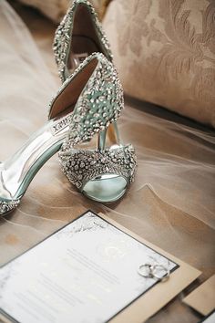 a pair of high heeled shoes sitting on top of a table next to a card