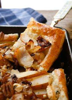 a close up of a piece of food in a pan on a table with a fork