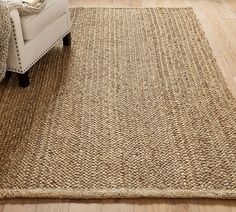 a living room with a chair and rug on the floor