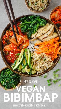 a bowl filled with vegetables and rice next to chopsticks on top of it