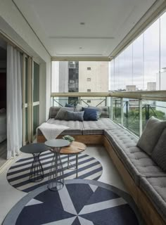 a living room filled with furniture next to a large window covered in lots of windows