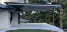 an outdoor covered patio with grass and trees in the background