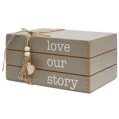 three wooden boxes with love our story written on the front and back, tied together