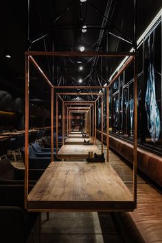 an empty room with wooden tables and blue chairs