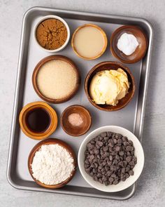 an assortment of different ingredients in bowls on a baking tray, including chocolate chips and vanilla ice cream