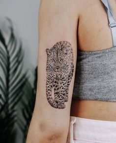 a woman's arm with a tattoo of a leopard on it