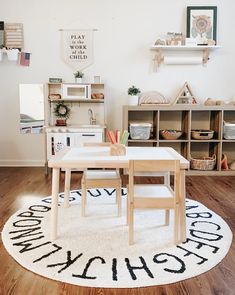 a child's playroom with white walls and wooden flooring, including a rug on the floor