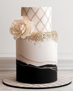 a white and black cake with gold decorations