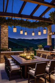 an outdoor dining table with lanterns hanging from it's ceiling and chairs around it