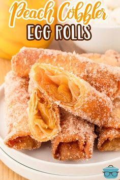 peach cobbler egg rolls on a white plate with text overlay that reads peach cobbler egg rolls