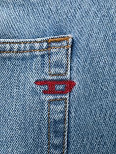 the back pocket of a pair of blue jeans with red stitching on it and an arrow