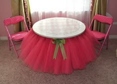 a pink tutule skirt sitting on top of a white table in front of a window