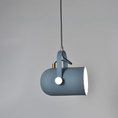 a blue light hanging from a gray ceiling with a black cord and two white lights