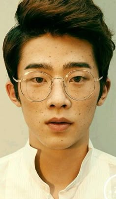 a young man wearing glasses and a white shirt