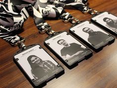 four id cards are attached to a lanyard on a wooden table with black and white designs