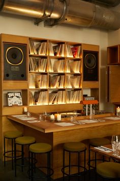 an empty restaurant with lots of books on the shelves and bar stools in front of it