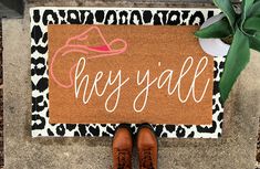 someone is standing in front of a door mat with the word hey y'all on it