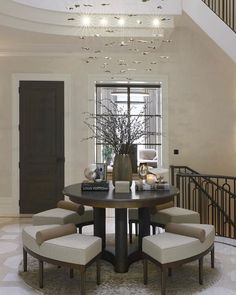 a dining room table with four chairs and a chandelier hanging from the ceiling