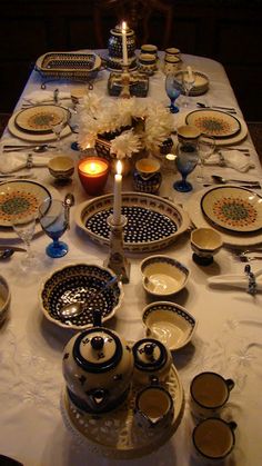 the table is set with dishes and candles