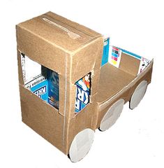 a cardboard box shaped like a carton with wheels and soda cans in the back