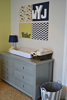 a baby's nursery room with a dresser, crib and wall hangings