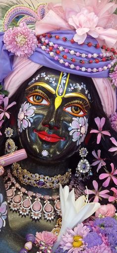 a close up of a statue with flowers around it