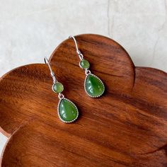 Stone Type: Nephrite Jade Metal: 925 Sterling Silver Earring Size (without hook): ~0.90 x 0.38 x 0.18 in. Drop Length: ~1.50 in. Earring Weight: ~3 g NATURAL JADE: This is a high grade jade earring. The stone is completely natural nephrite jade. DESCRIPTION: The "Forest Dew Drops"  earrings are inspired by the serene beauty of morning dew in the forest. Each earring features a perfectly polished, teardrop-shaped nephrite jade stone, cradled in a sleek sterling silver setting. Above the teardrop, a smaller round jade stone adds balance and harmony to the design. The verdant hue of the jade captures the essence of dew-kissed leaves, enhancing any outfit with its natural elegance. With secure and comfortable sterling silver hooks, these earrings are perfect for both everyday wear and special Jade Dangle Earrings, Morning Dew, Jade Earrings, Dew Drops, Nephrite Jade, Earrings Green, Natural Jade, Jade Stone, Silver Earring