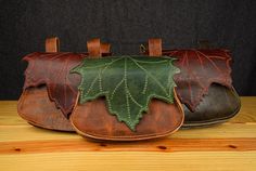 three leather bags with green leaves on them