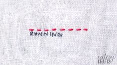 the word running written in red thread on a white piece of cloth with an arrow