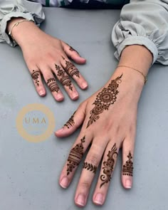 two hands with henna tattoos on them