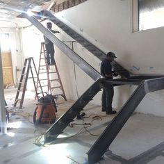 two men are working on an unfinished staircase