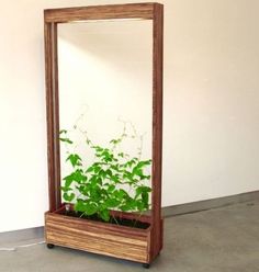 a wooden planter sitting on top of a floor next to a wall with a mirror above it