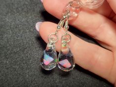 "Make a splash with these Mermaid's Tears earrings!  These gorgeous hand-blown teardrop earrings are made with only the highest quality borosilicate glass and features a mesmerizing Gilson opal polished nugget that shimmers with blue, green, yellow, and even a hint of red within the opal encased in glass. These earrings come mounted on sturdy sterling silver fish hooks, perfect for those with sensitive ears. And with a heavy gauge sterling that won't bend out of shape, you can wear these earring Glass Drop Earrings With Matching Set, Glass Teardrop Jewelry With Matching Earrings, Nickel-free Glass Drop Jewelry, Unique Teardrop Crystal Earrings For Jewelry Making, Clear Glass Drop Jewelry, Clear Drop-shaped Glass Jewelry, Iridescent Teardrop Crystal Earrings, Nickel-free Teardrop Glass Jewelry, Iridescent Drop Earrings For Gift