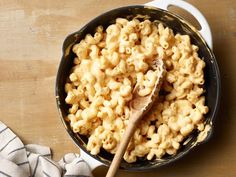 macaroni and cheese in a skillet with a wooden spoon