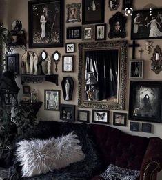 a living room filled with lots of framed pictures on the wall and a couch in front of it