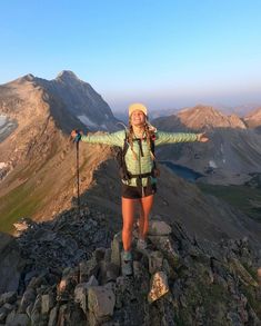 a woman standing on top of a rocky mountain