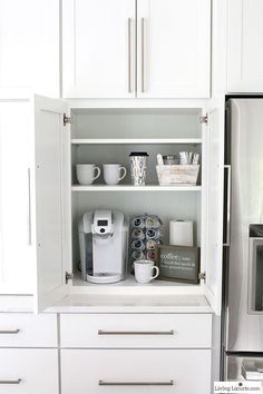 a kitchen with white cupboards and stainless steel refrigerator freezer next to coffee maker