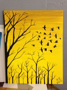 a painting with birds flying in the sky above trees and yellow background, on a table