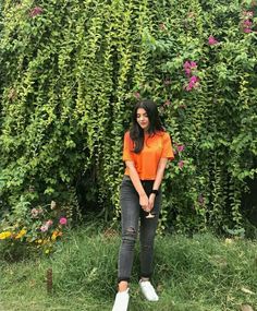 a woman standing in front of a bush