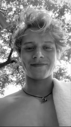 black and white photograph of a young man with short hair wearing a bathrobe