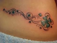 a woman's stomach with a clover tattoo on it