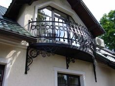 an iron balcony on the side of a house